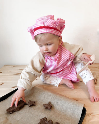 Toddler baking cookies in Chef's Set for World Kindness Day