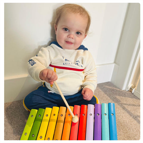 Baby playing with Snazzy Xylophone music toy