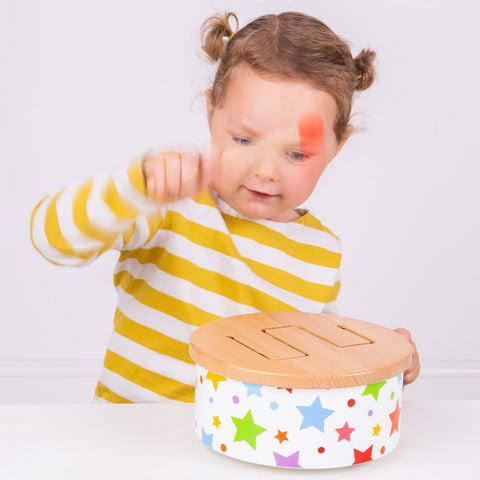 Girl playing with Wooden Drum musical toy