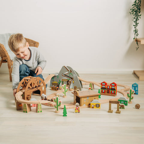 Boy playing with Wild West Wooden Train Set
