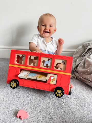 Baby playing with Red Bus Sorter animal toys