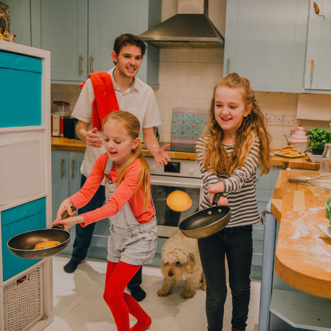 Pancake Day activities: Family having a pancake tossing race