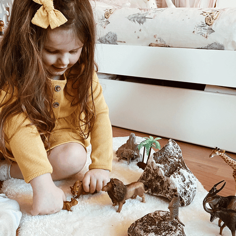 Girl playing with CollectA's realistic animal toys
