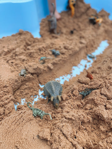 Dinosaur figures in sandpit