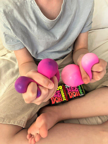 Boy squeezing NeeDoh sensory balls from a sensory box