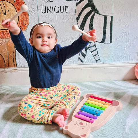 Baby playing with xylophone musical instrument