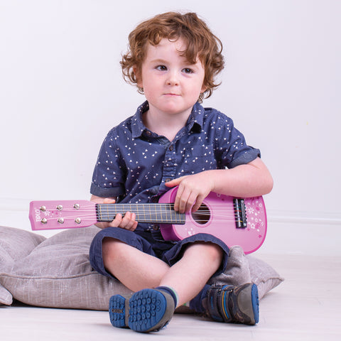 Boy playing on his Pink Kids Guitar Christmas gift