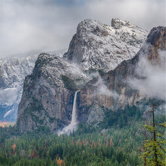 Photo of the Three Brothers rock formation in Yosemite Valley with light fog.