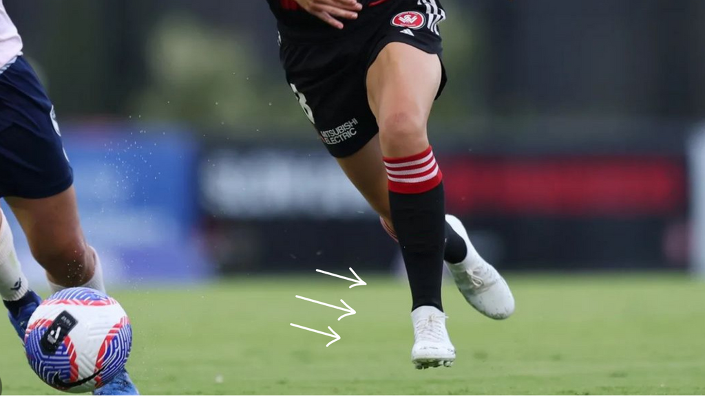 Women's soccer player running in a game wearing white IDA Rise women's soccer cleats