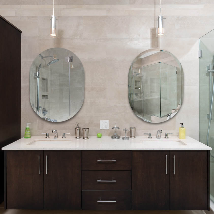 Oval racetrack mirrors in bathroom above double sink vanity