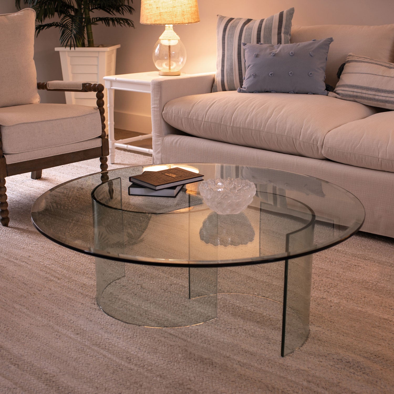 Round clear glass table with beveled edges on top of clear glass half circle base