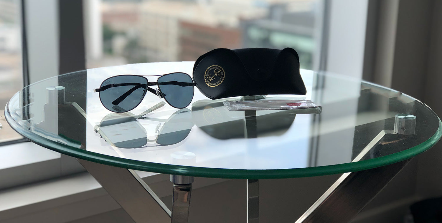 Ray Ban glasses and case on round clear glass table