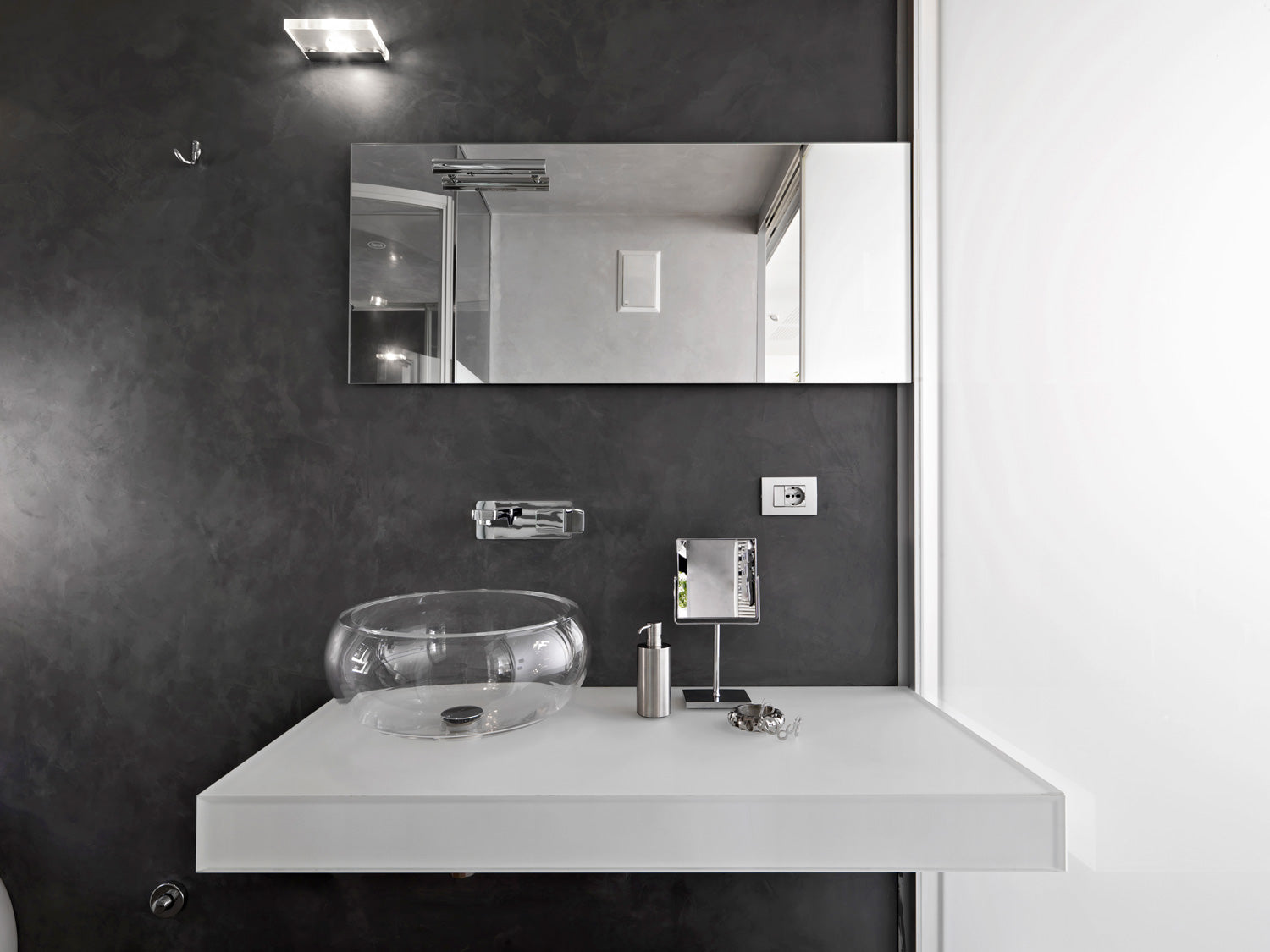 Rectangle horizontal frameless mirror above glass bowl sink