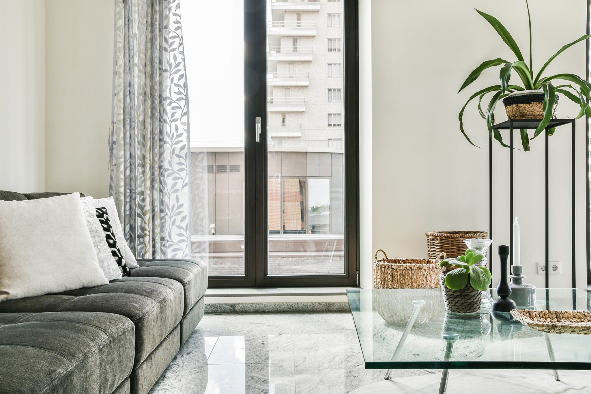 Square clear glass table with flat polish edges and two tall glass doors in the background