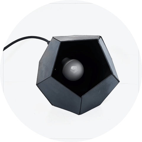 Une Lampe de Chevet Design de couleur noir artisanale aux côtés pentagonales.