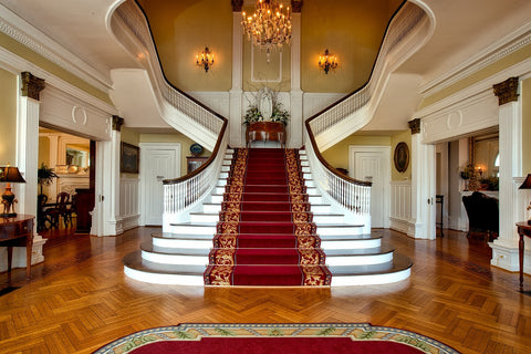 un escalier dans une demeure luxueuse éclairé par un lustre féérique