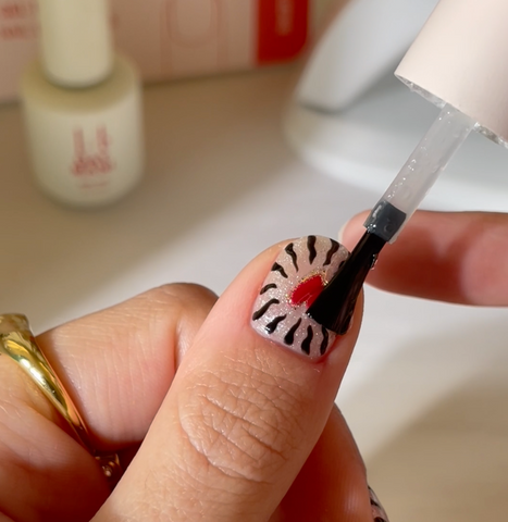 Clear top coat being applied to nail design