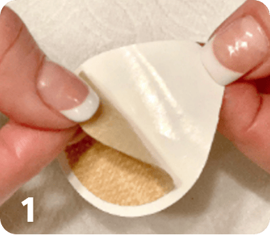 thumbs and index fingers from both hands are used to peel the adhesive from the patch