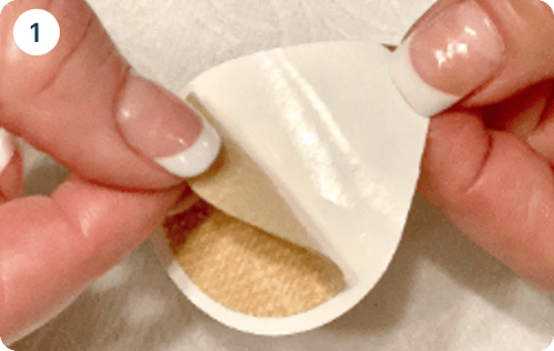 thumbs and index fingers from both hands are used to peel the adhesive from the patch
