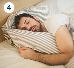 a man is sleeping while hugging a pillow.