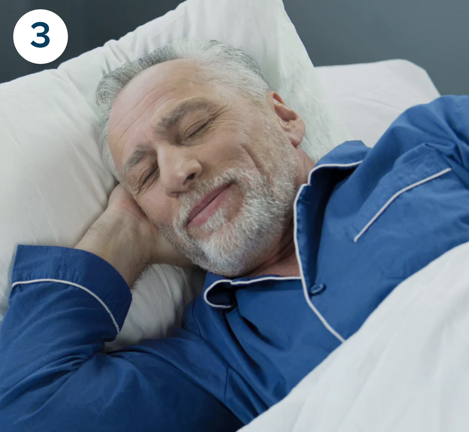 A senior man wearing blue sleepwear is sleeping soundly.