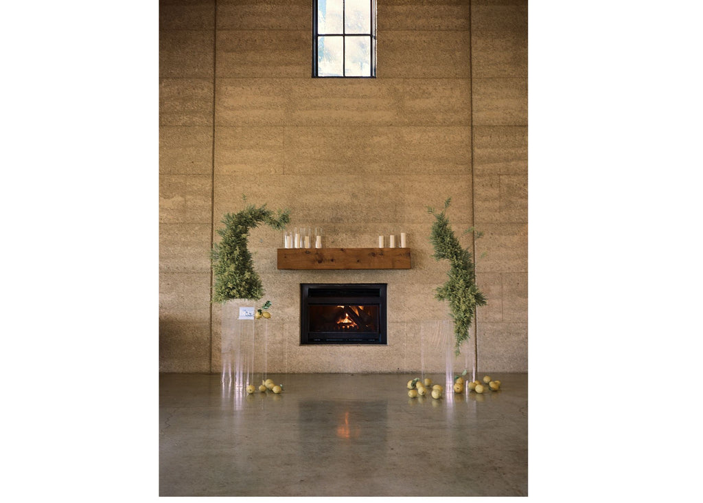 Golden rod sculptures by the fireplace. Candles on the fireplace mantle. Clear perspex plinths making the flowers seem like they float in mid air above some fragrant lemons!