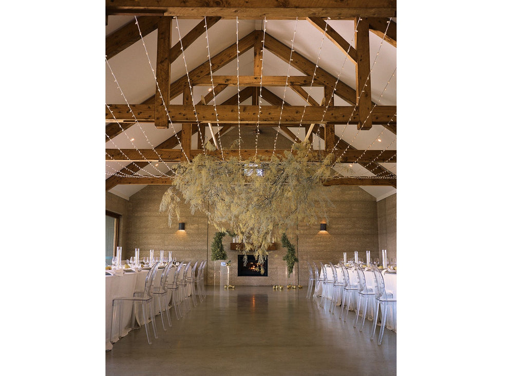 wattle cloud suspended between two long tables dressed in white linen