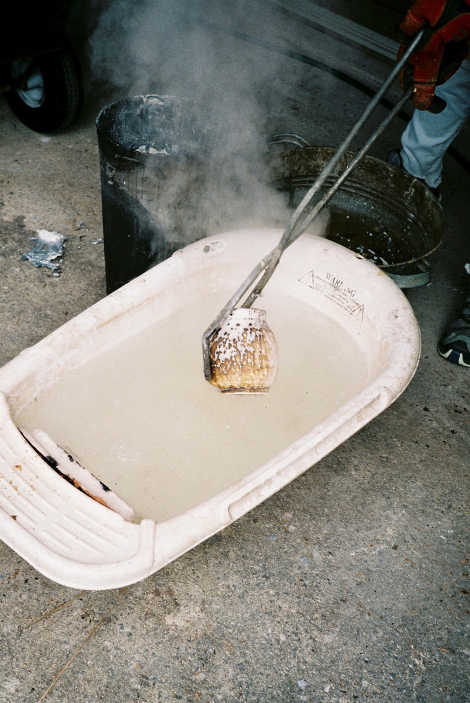 Obvara pot being placed into a water bath