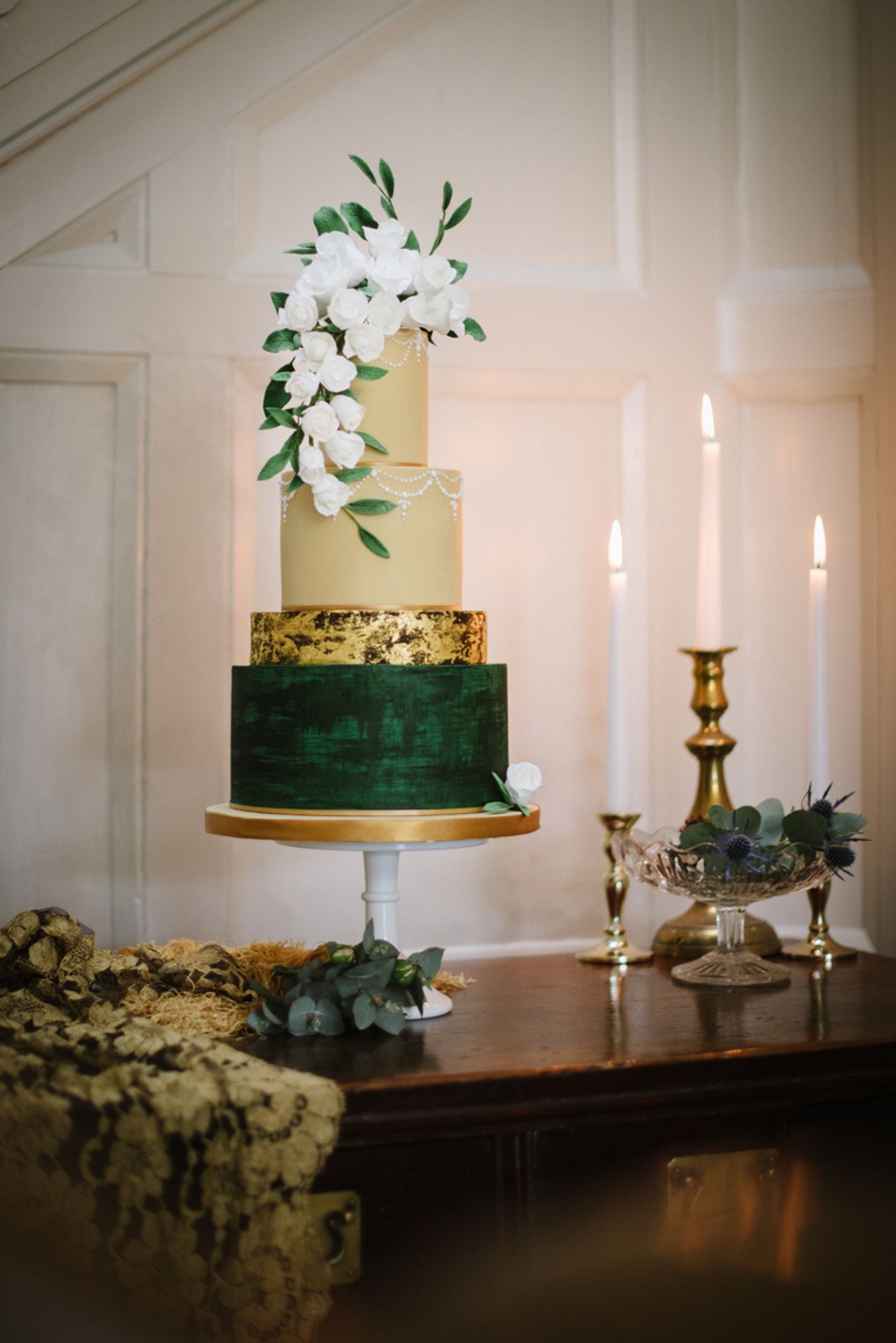 Elegant four tier wedding cake, gold leaf, blush and green with flower cascade topper
