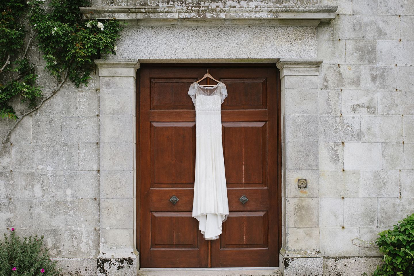 Art Deco wedding dress hanging on country house door