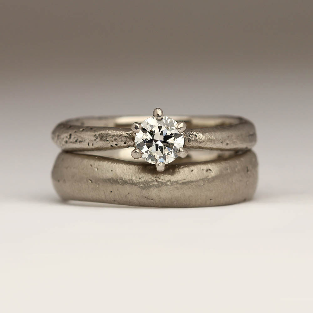 Chunky wedding ring next to engagement ring