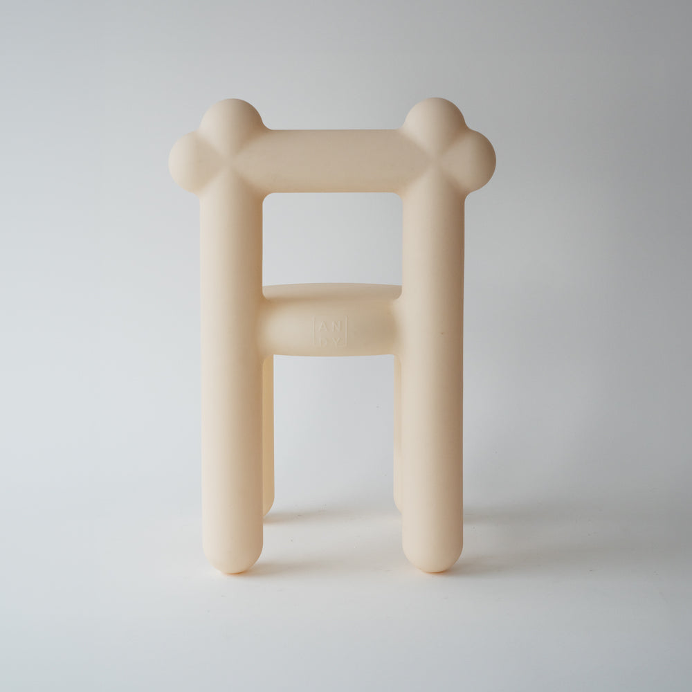 Beige designer stool with a minimalist, rounded design against a white background.