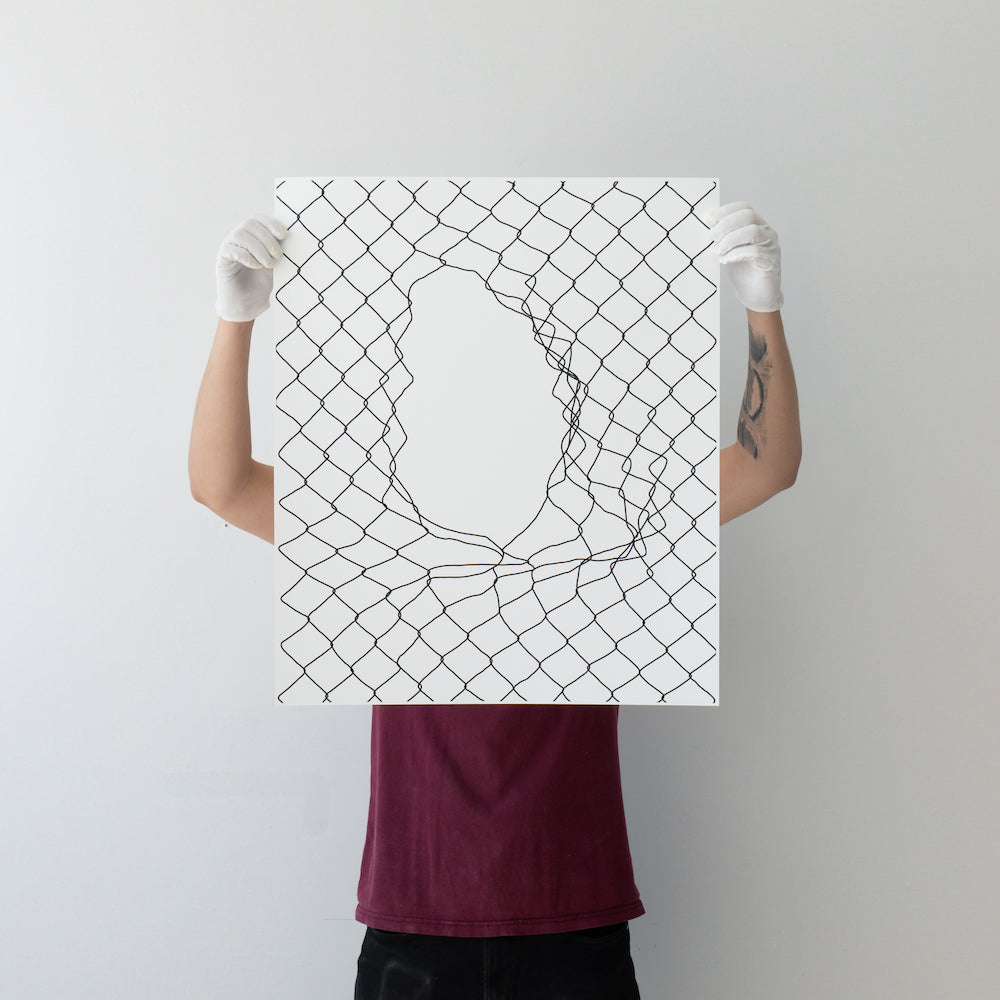 Person holding a canvas with abstract net-like design in front of their face.