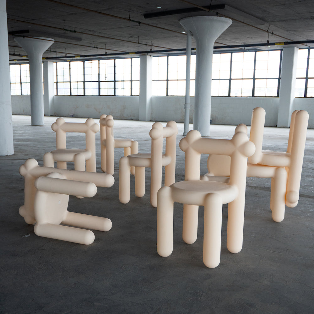 Sculptural beige chairs resembling balloon animals inside an empty industrial space.