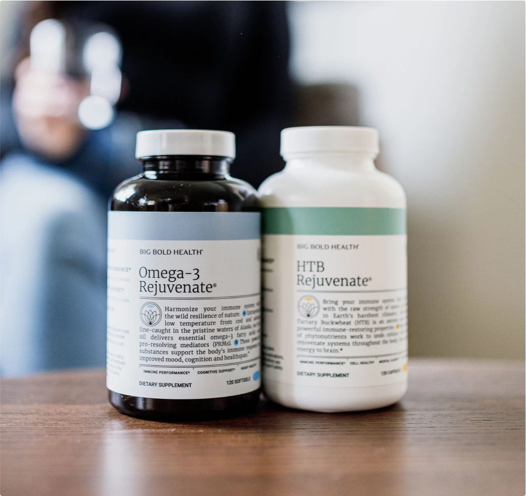 Two bottles of dietary supplements, Omega-3 Rejuvenate and HTB Rejuvenate, are placed on a wooden surface.