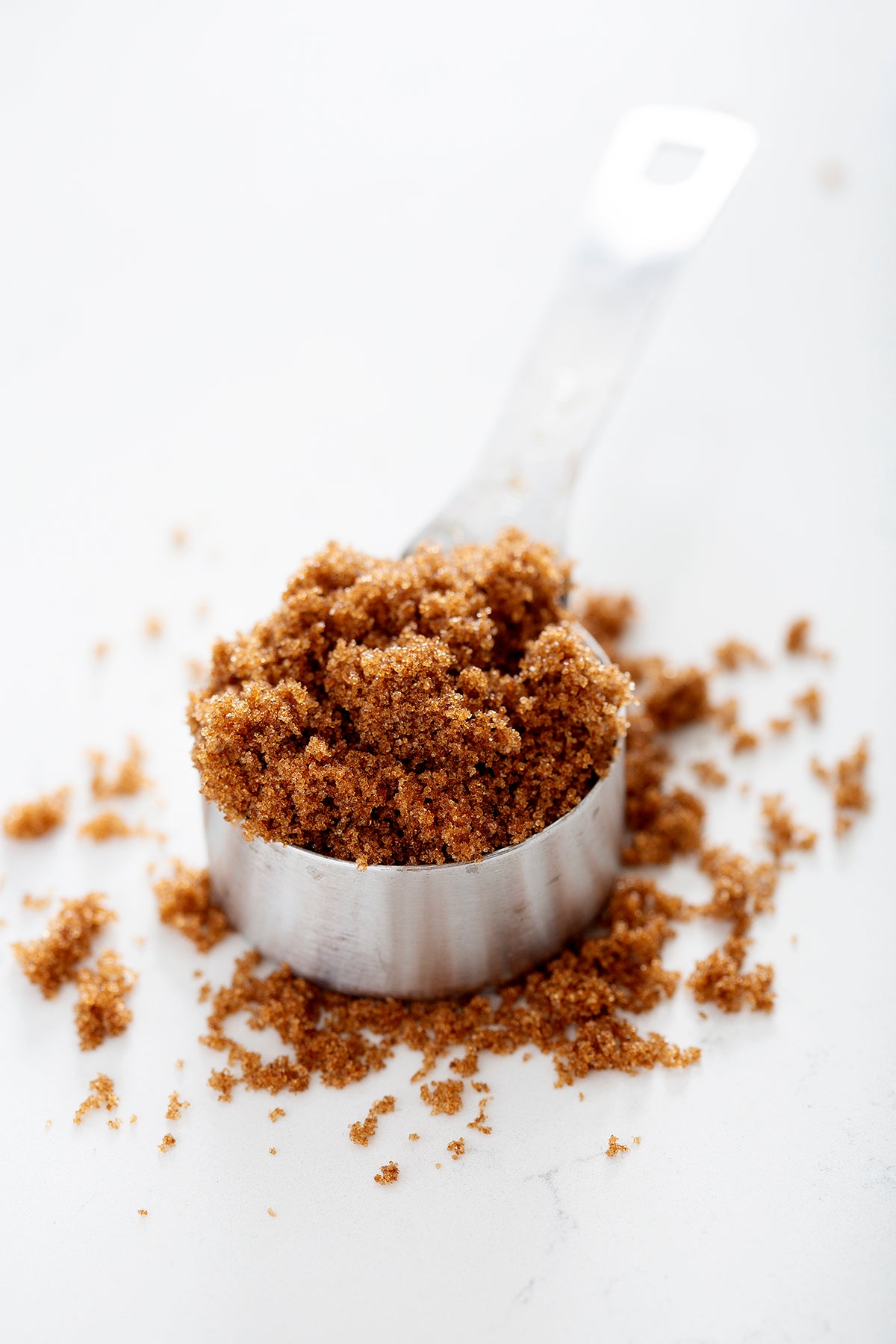 measuring cup overflowing with brown sugar