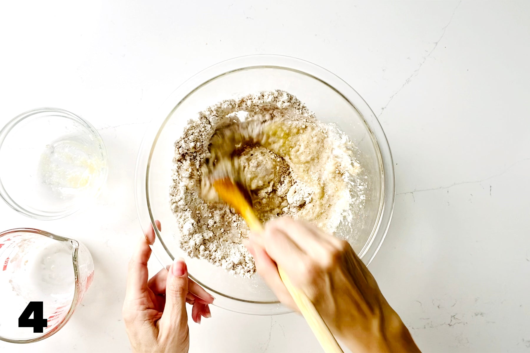 stirring flour with wooden spoon in glass bowl