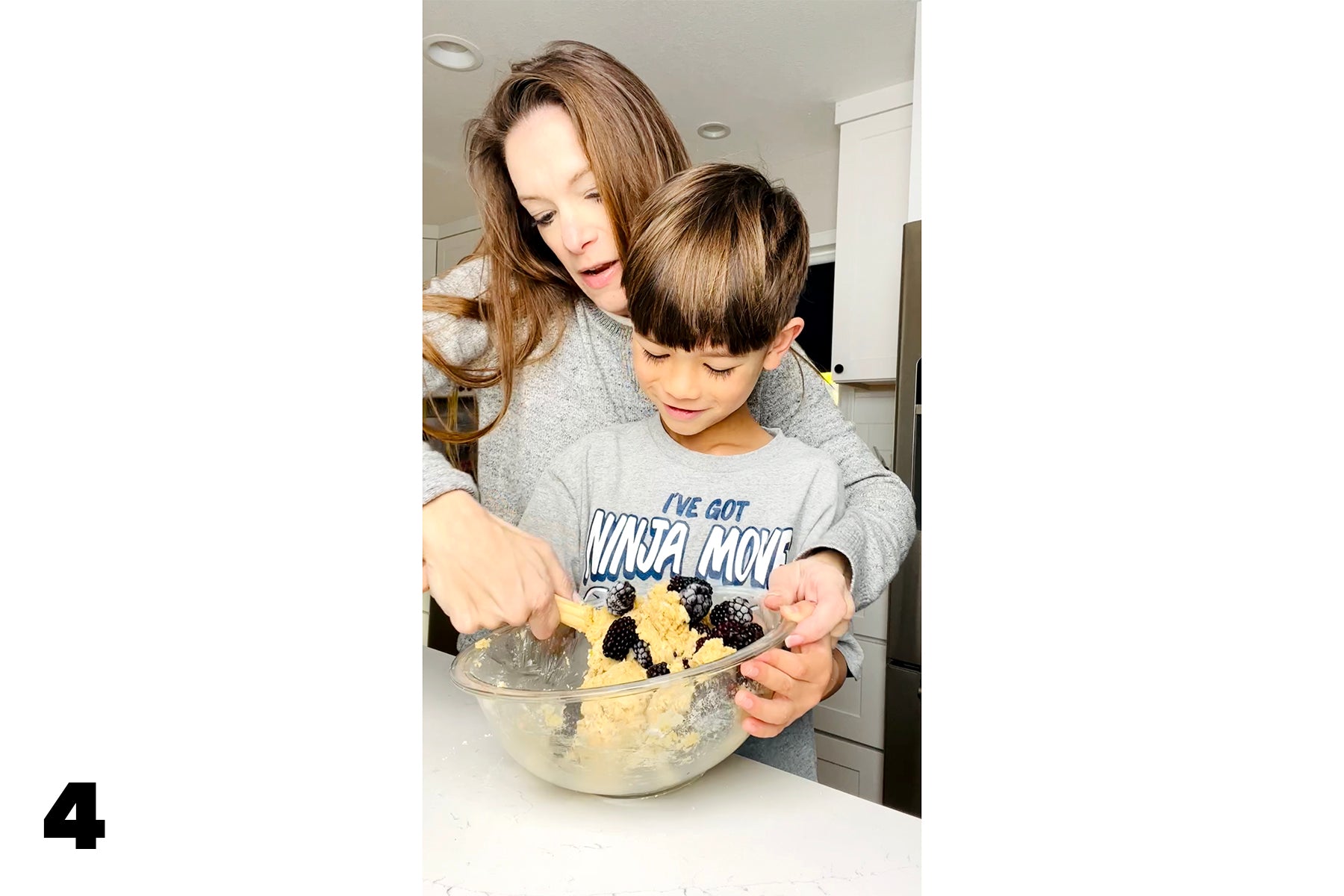 mother and child mixing dough with blackberries