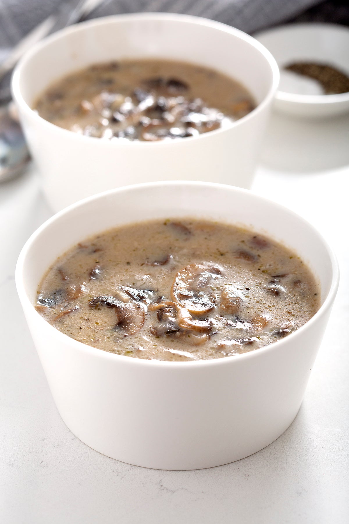 two white bowls of cream of mushroom soup