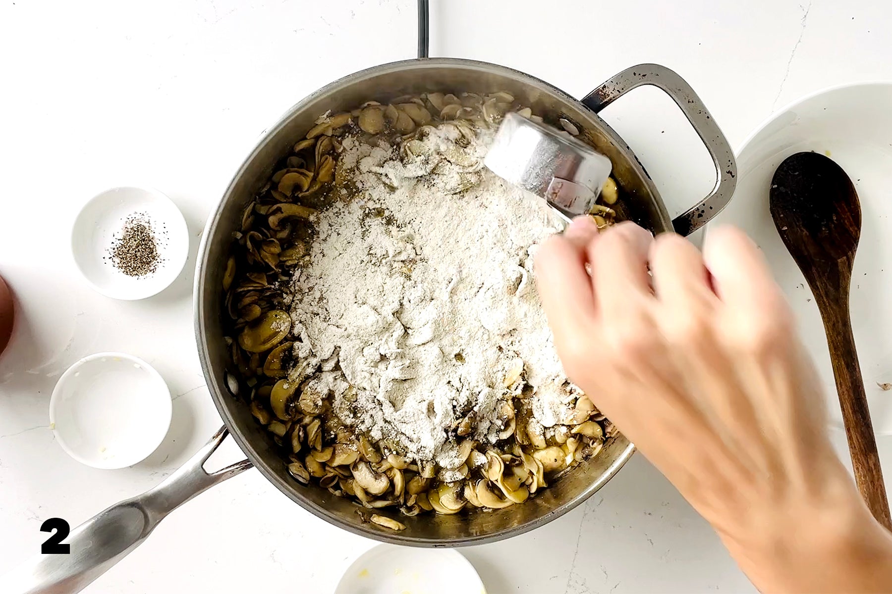 sprinkling Beth Blends Gluten Free Gravy Mix on mushrooms in pan