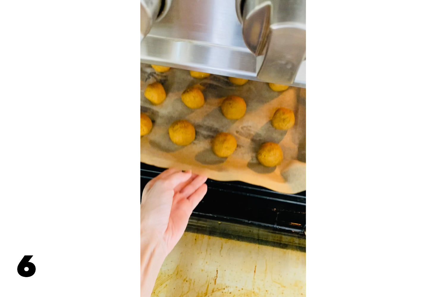 hand putting cookie sheet into oven