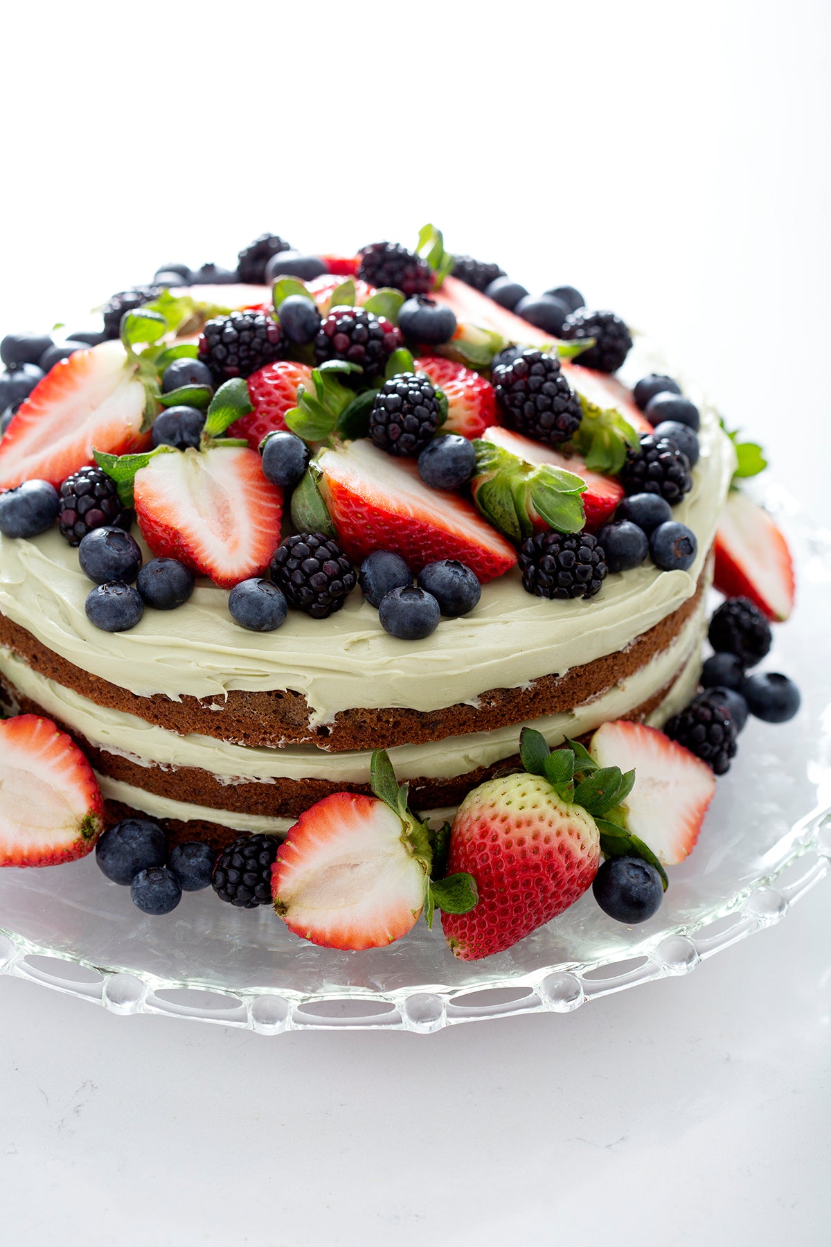 fruit and green frosting on layered gluten free matcha cake