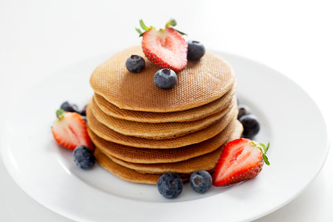 stack of paleo pancakes with strawberries and blueberries