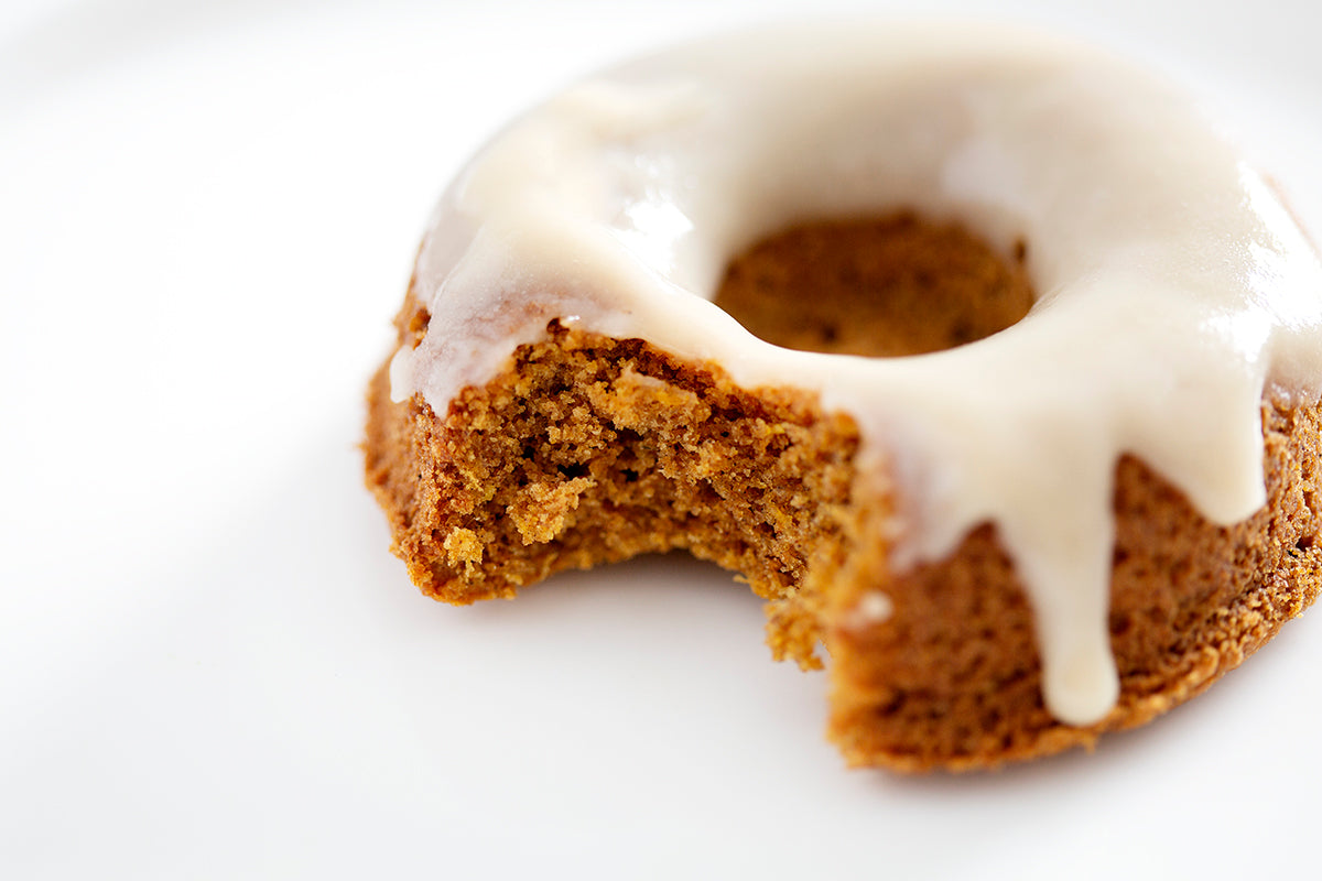 close up of paleo pumpkin donut with maple glaze with bite missing