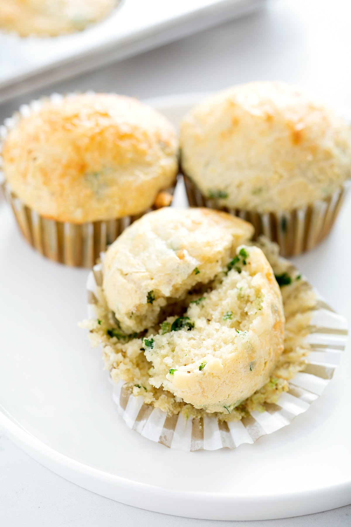 savory muffins on white plate with one split in half and buttered