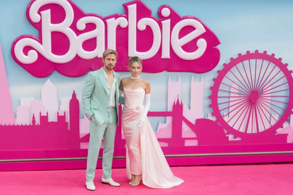 Photo of actor Ryan Gosling and Margot Robbie at the Barbie Premiere in London with the Barbie logo behind them.
