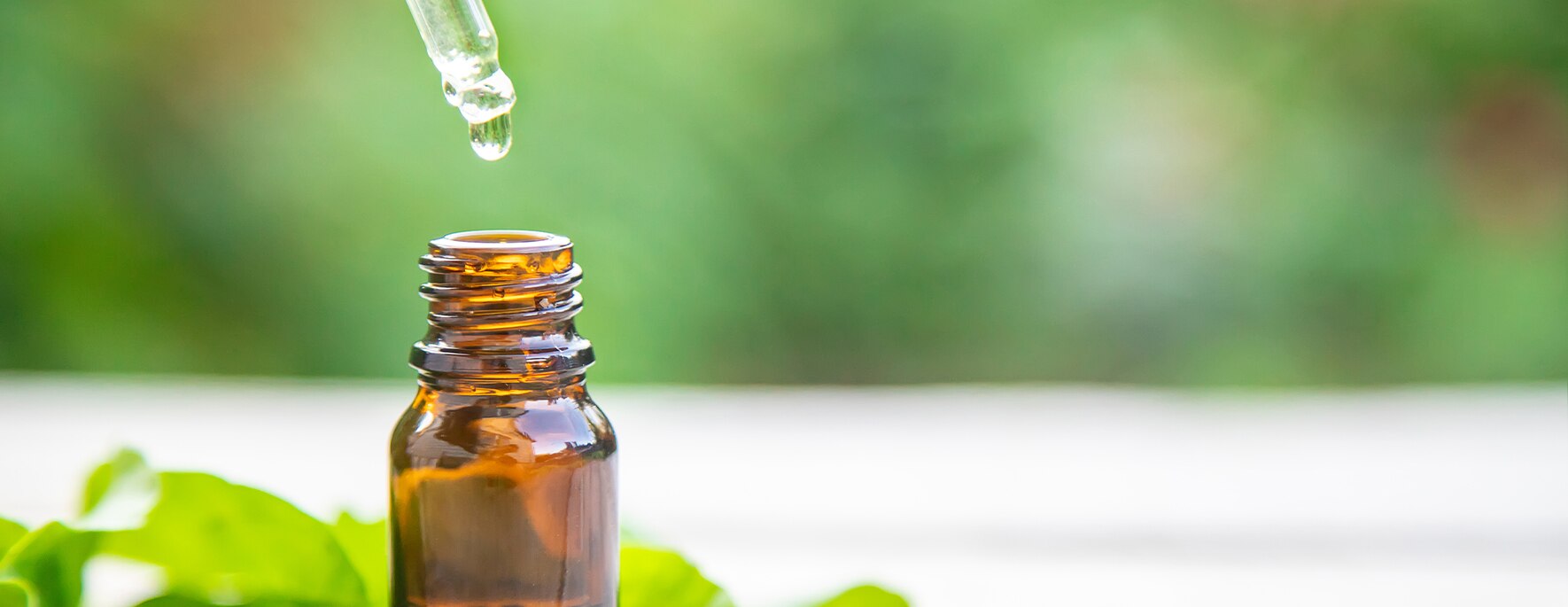 A drop of kratom extract dropping in the jar from a dropper