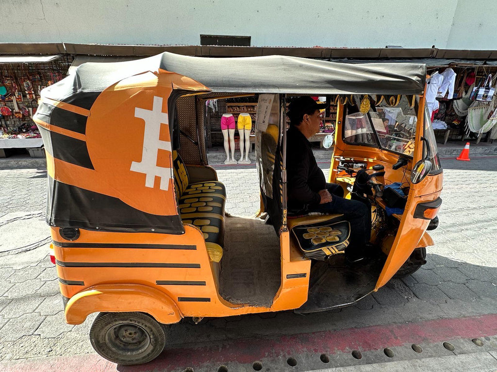 tuk-tuk in guatemala painted in orange with the bitcoin logo