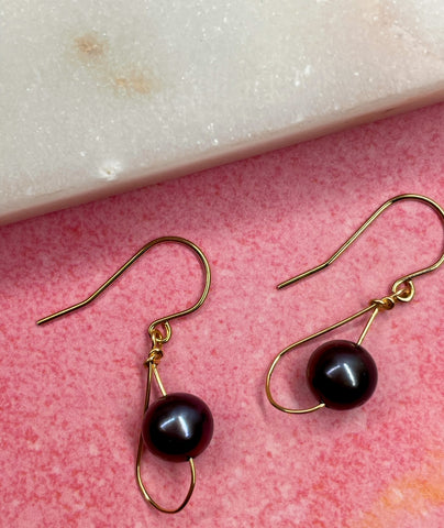 Black pearl drop earrings with 14K gold details.