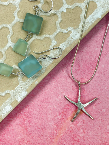 Blue beach glass abstract earrings and sterling silver dainty starfish necklace.